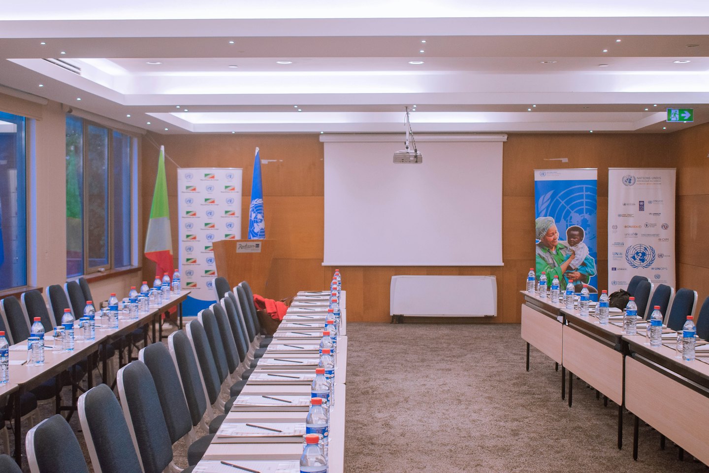 Conference room tables arranged for a meeting with UN banners.